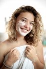 Adolescente avec masque facial dans la salle de bain — Photo de stock