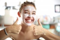Teenager Mädchen mit Gesichtsmaske im Badezimmer — Stockfoto