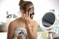 Девочка-подросток в маске для лица в ванной — стоковое фото