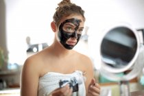Девочка-подросток делает маску для лица — стоковое фото