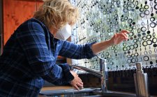 La vita quotidiana durante l'epidemia di Coronavirus, donna che pulisce la casa in maschera — Foto stock