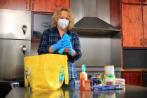 Щоденне життя під час епідемії коронавірусу жінка в масці прибирає дім. — стокове фото