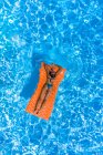 Frau auf Luftmatratze in Schwimmbad — Stockfoto