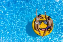 Junges Paar und Smiley-Boje am Pool — Stockfoto