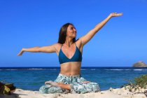 Young woman doing yoga on the beach — Stock Photo