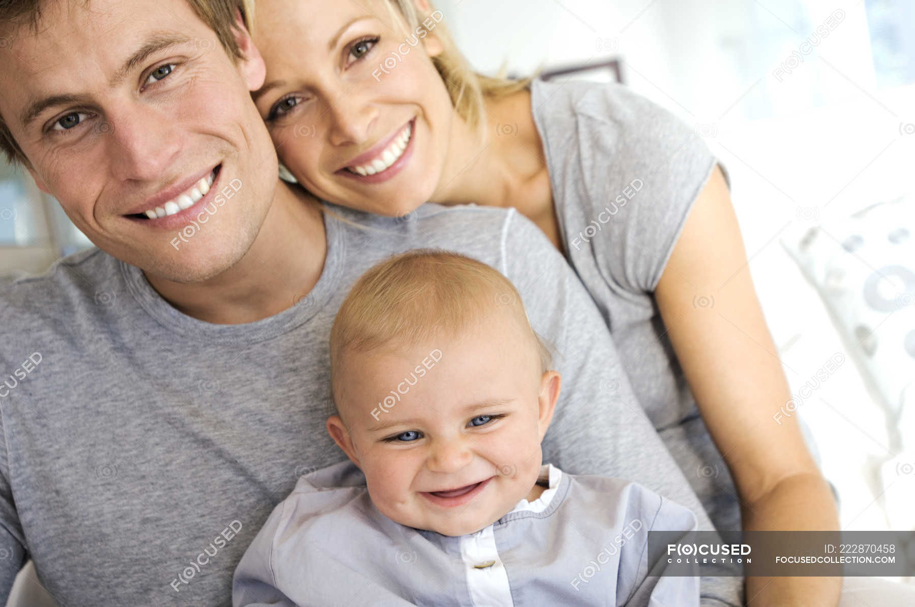 Portrait Of Happy Parents And Baby At Home Smiling Father Stock Photo