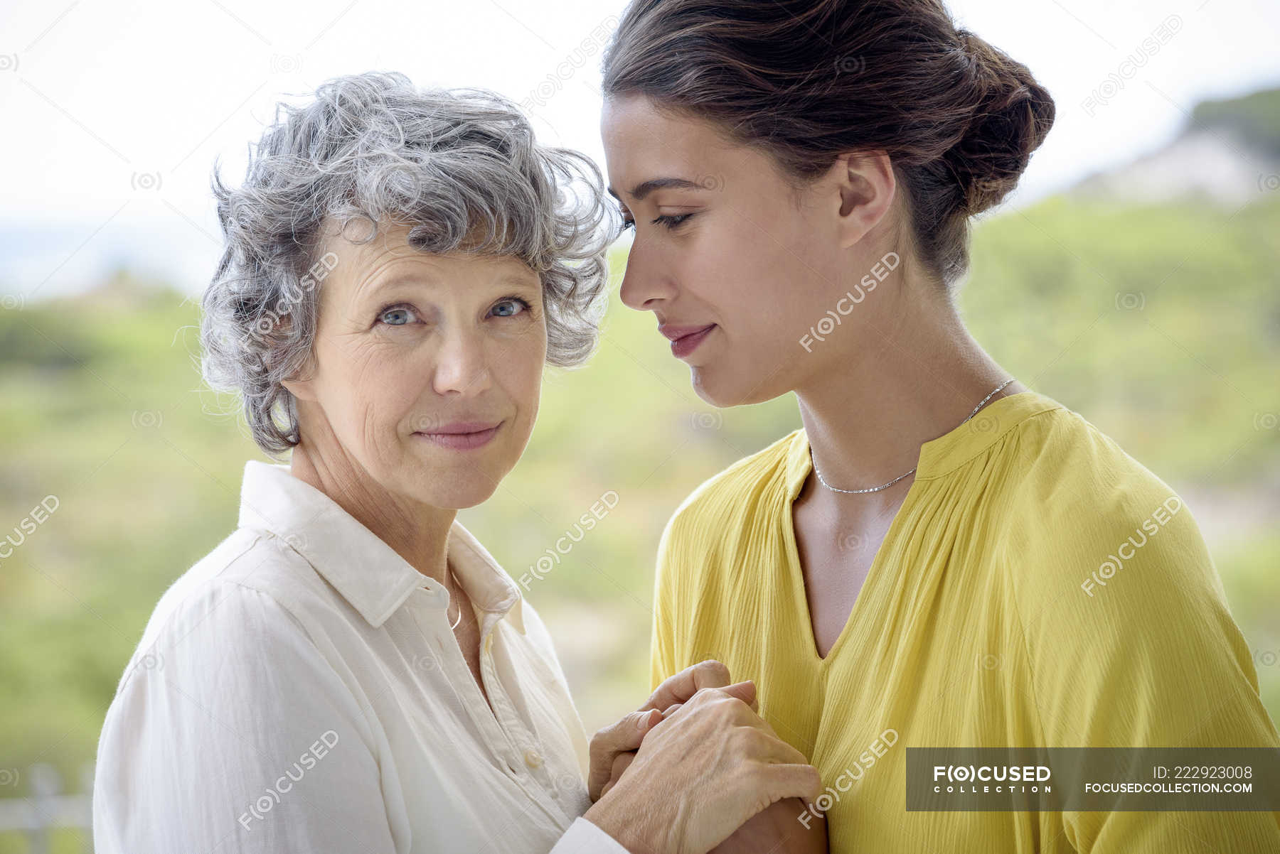 Portrait Of Loving Mother And Daughter Holding Hands Outdoors