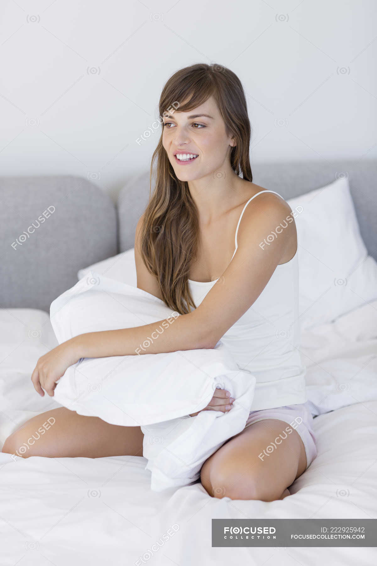 Happy Young Woman Sitting On Bed With Pillow Brown Hair Toothy