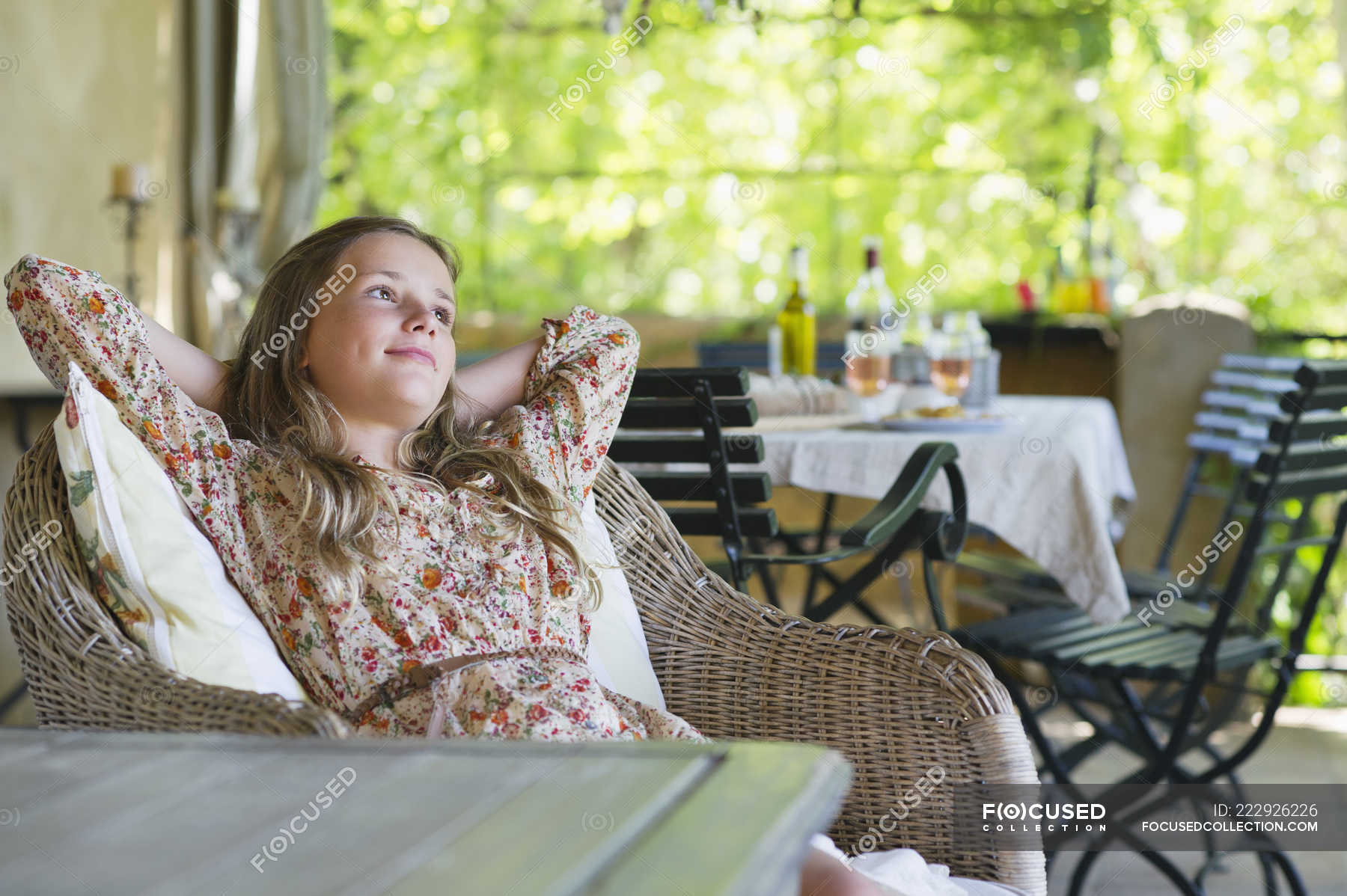 Dreamy girl sitting and looking away with food on table on background ...