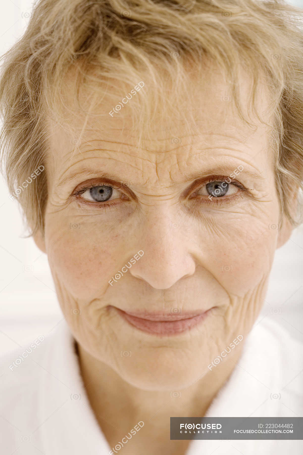 Portrait of senior woman with short hair looking at camera — skin