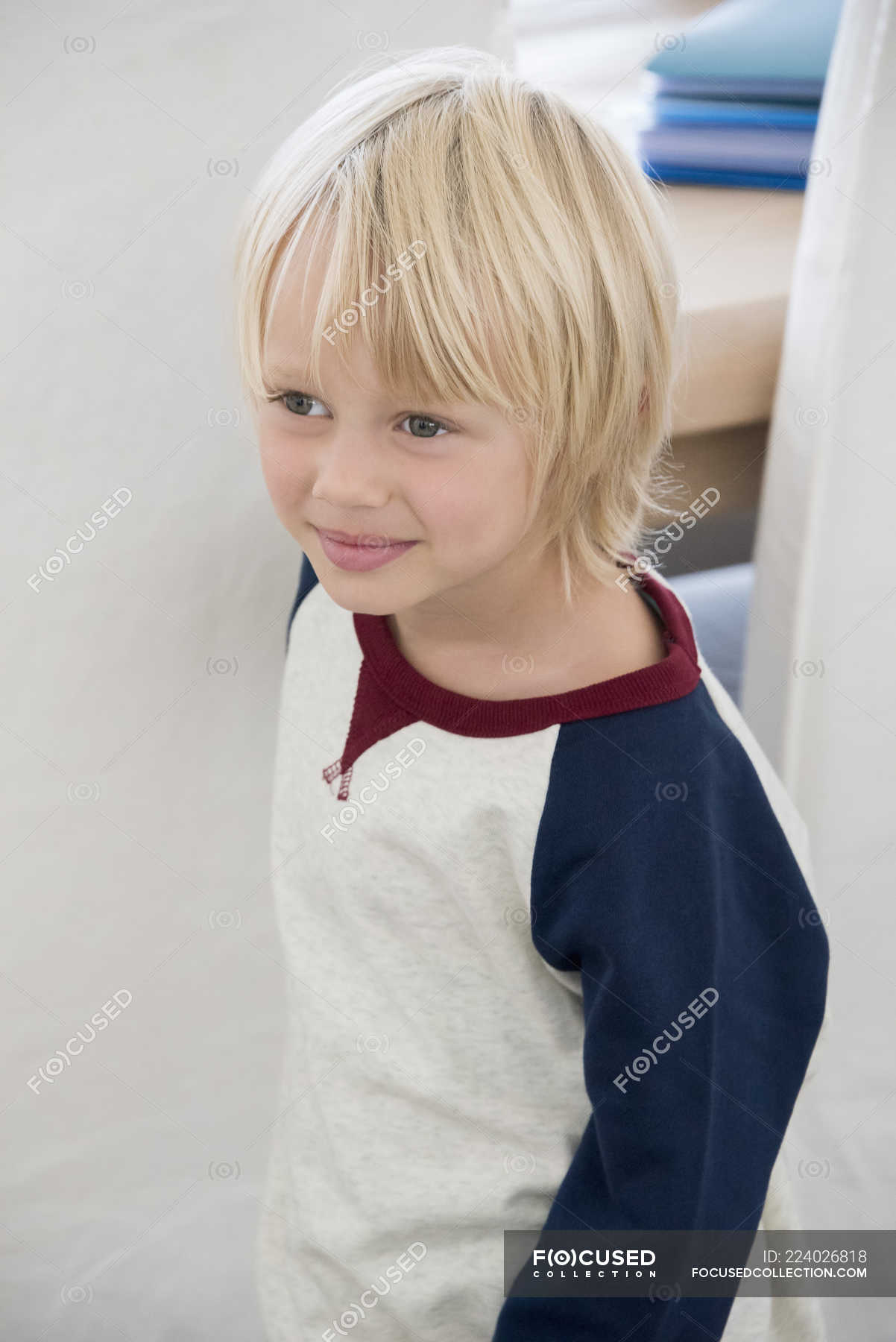 Close Up Of Happy Little Boy With Blonde Hair Looking Away Indoors