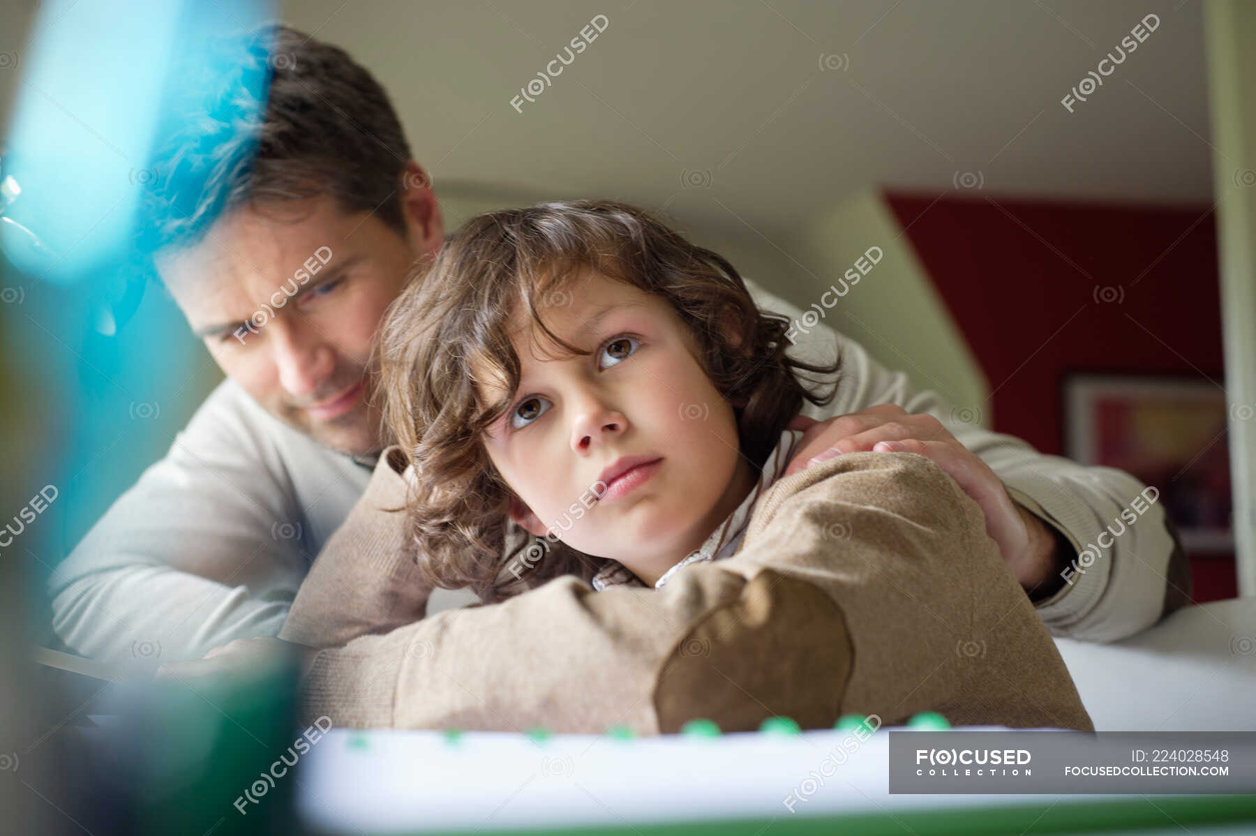 Boy thinking while studying with his father at home — homework ...