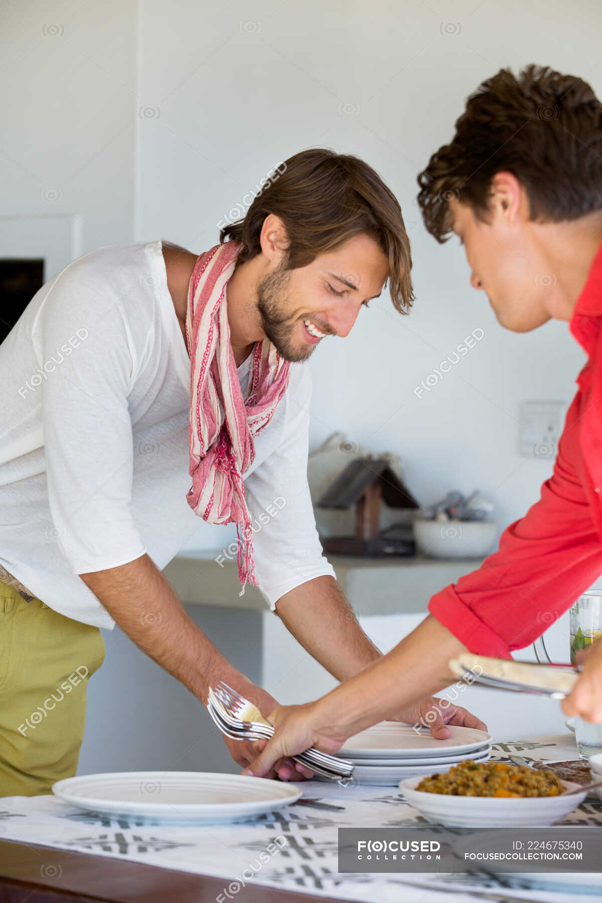 Friends arranging plates on a dining table — arrange, Two People