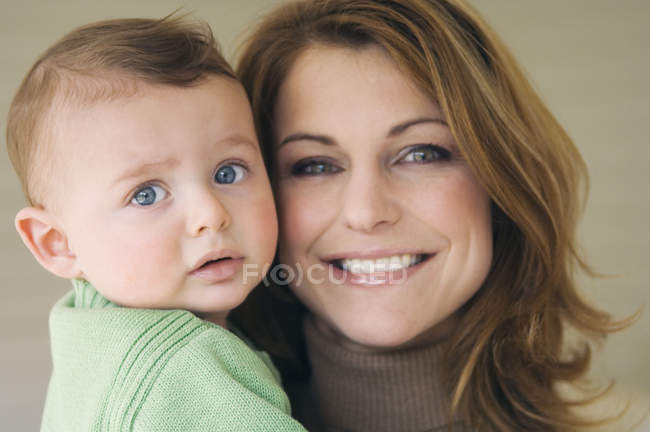 Portrait of smiling mother and baby boy face to face — Stock Photo