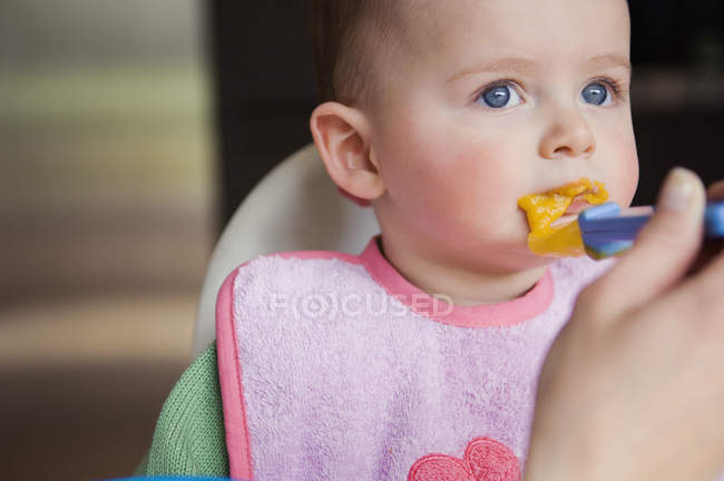 Primer plano de alimentación lindo bebé niño - foto de stock