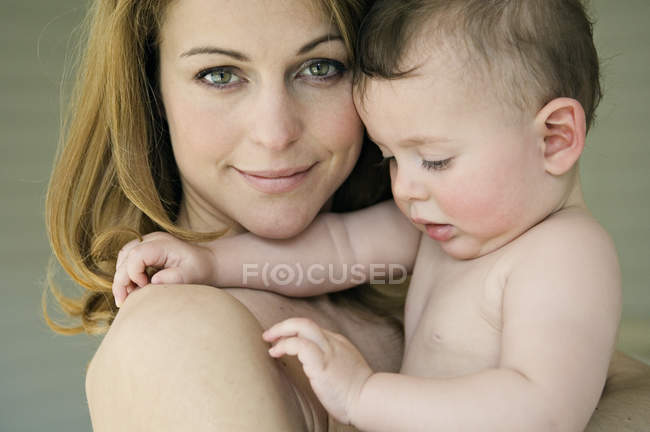 Porträt einer lächelnden Mutter und eines hemdlosen Jungen — Stockfoto