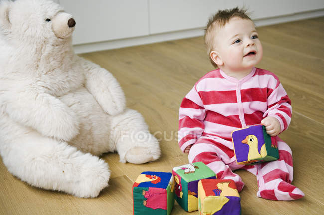 Felice bambino che gioca, seduto sul pavimento — Foto stock