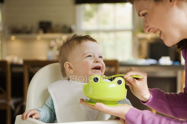 Madre alimentando a su bebé - foto de stock