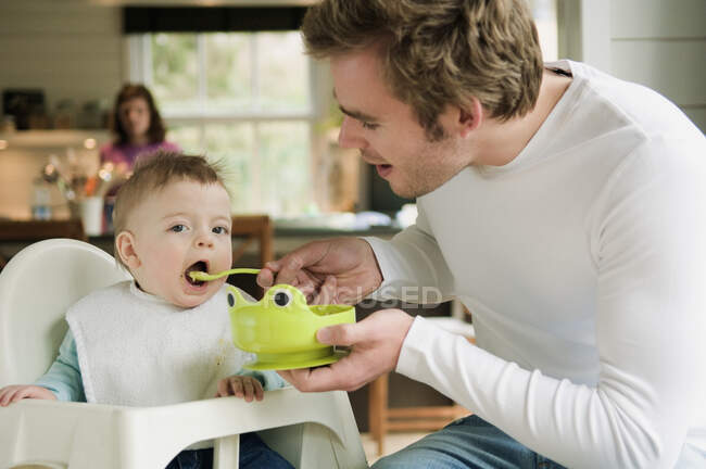 Father feeding her baby — Stock Photo