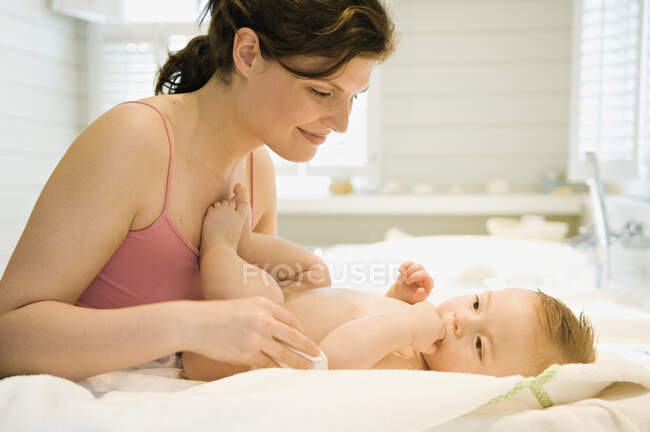 Mother and naked baby, cleanser cotton — Stock Photo