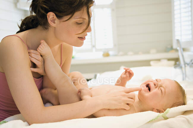 Mother and naked baby, crying — стоковое фото