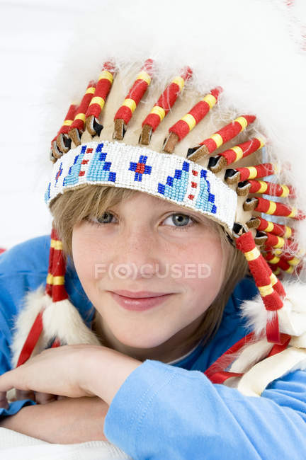 Portrait of young boy with indian headdress looking at camera — Stock Photo