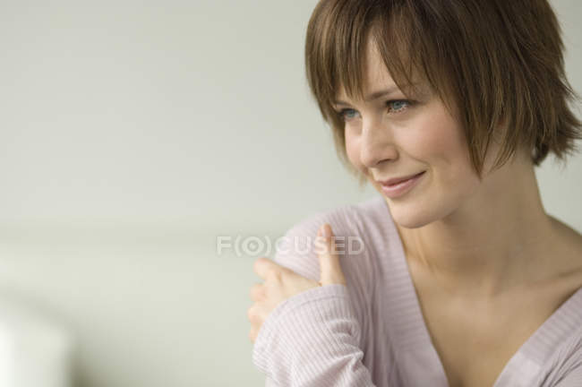 Портрет улыбающейся женщины с короткими волосами, смотрящей в сторону — стоковое фото