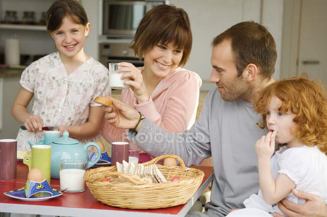 Pareja y 2 niñas desayunando - foto de stock