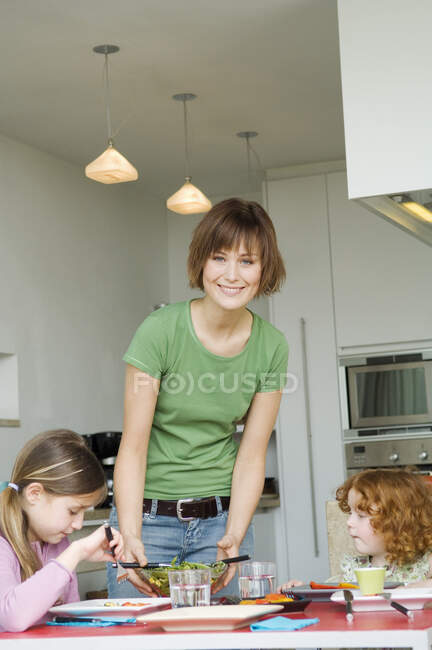 Frau und 2 kleine Mädchen beim Mittagessen — Stockfoto