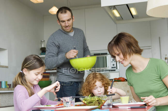Pareja y 2 niñas almorzando - foto de stock