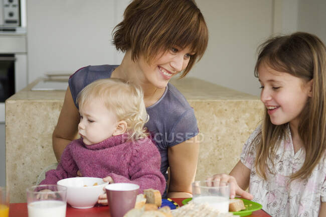 Frau und 2 Kinder am Frühstückstisch — Stockfoto