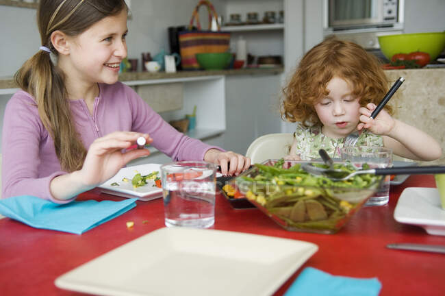 2 little girls at lunch table — Stock Photo