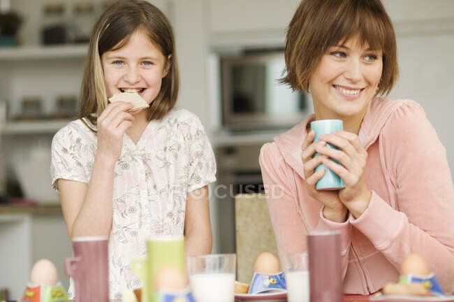 Femme et petite fille à la table du petit déjeuner — Photo de stock