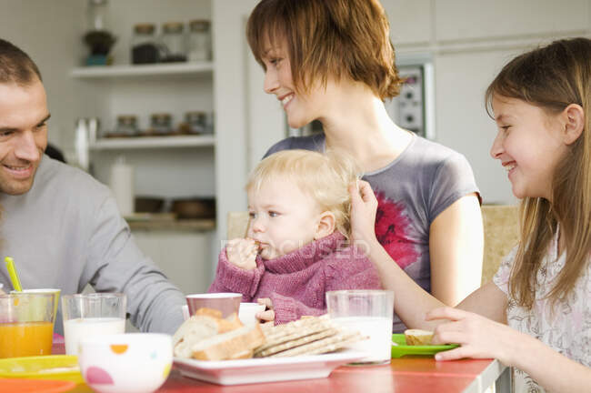 Couple et 2 enfants à la table du petit déjeuner — Photo de stock