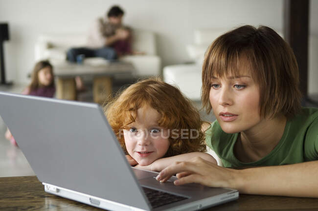 Mulher e menina usando computador portátil — Fotografia de Stock