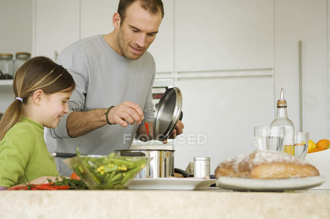 Man and little girl cooking at domestic kitchen — Stock Photo