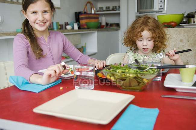 Dos niñas en la mesa del almuerzo, enfoque selectivo - foto de stock
