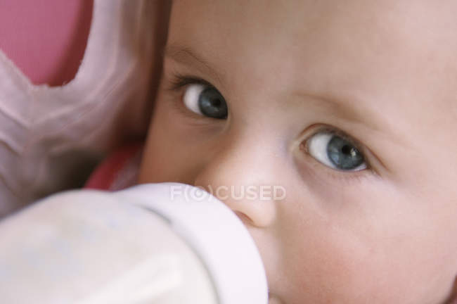 Primo piano del bambino che allatta il biberon dei genitori — Foto stock