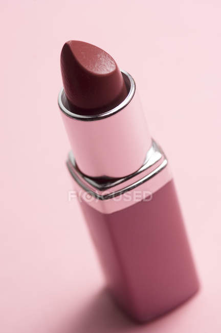 Nahaufnahme klassischer roter Lippenstift auf rosa Hintergrund — Stockfoto