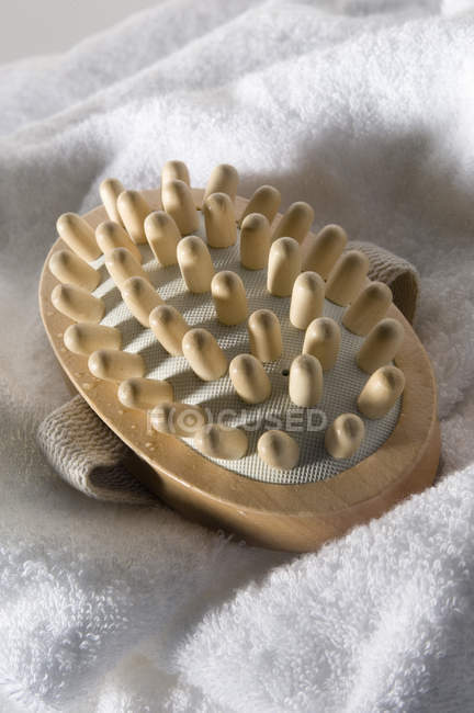 Close-up de massageador de madeira na toalha de banho branca — Fotografia de Stock