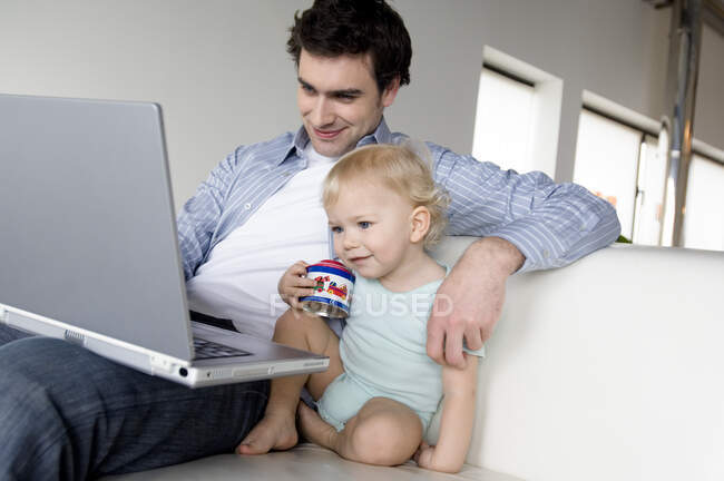 Мужчина и маленький мальчик с ноутбуком — стоковое фото