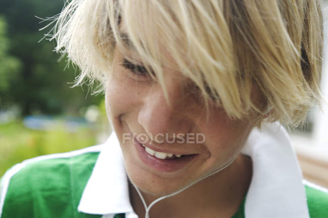 Retrato del adolescente rubio sonriente sobre fondo borroso - foto de stock