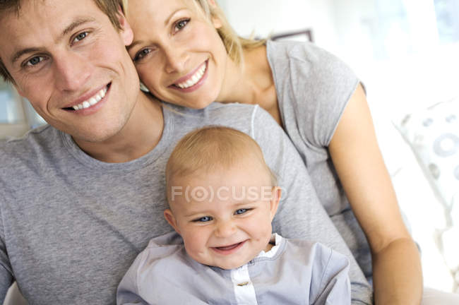 Portrait de parents heureux et bébé à la maison — Photo de stock