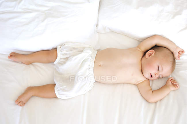 Cute baby boy sleeping on bed — Stock Photo
