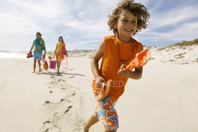 Родители и маленький мальчик прогуливаются по пляжу, на открытом воздухе — стоковое фото