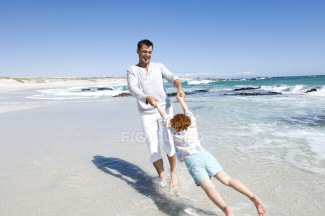 Батько грає з дочкою на пляжі, на відкритому повітрі — стокове фото