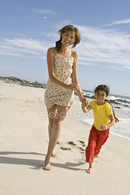 Mãe e filha andando na praia, ao ar livre — Fotografia de Stock