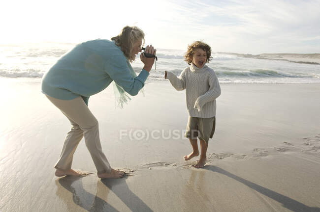 Бабушка и внук на пляже — стоковое фото