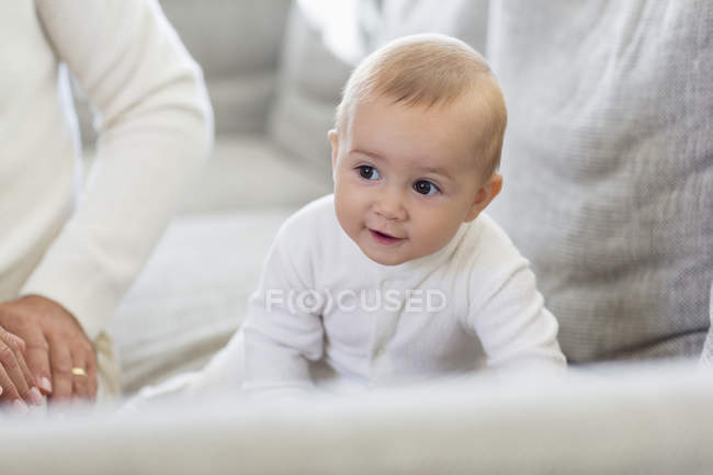 Happy baby girl crawling on couch at home — Stock Photo