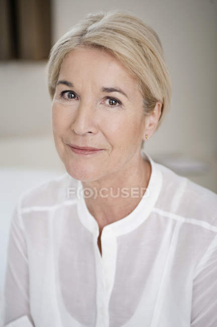 Портрет улыбающейся элегантной женщины в белой рубашке — стоковое фото